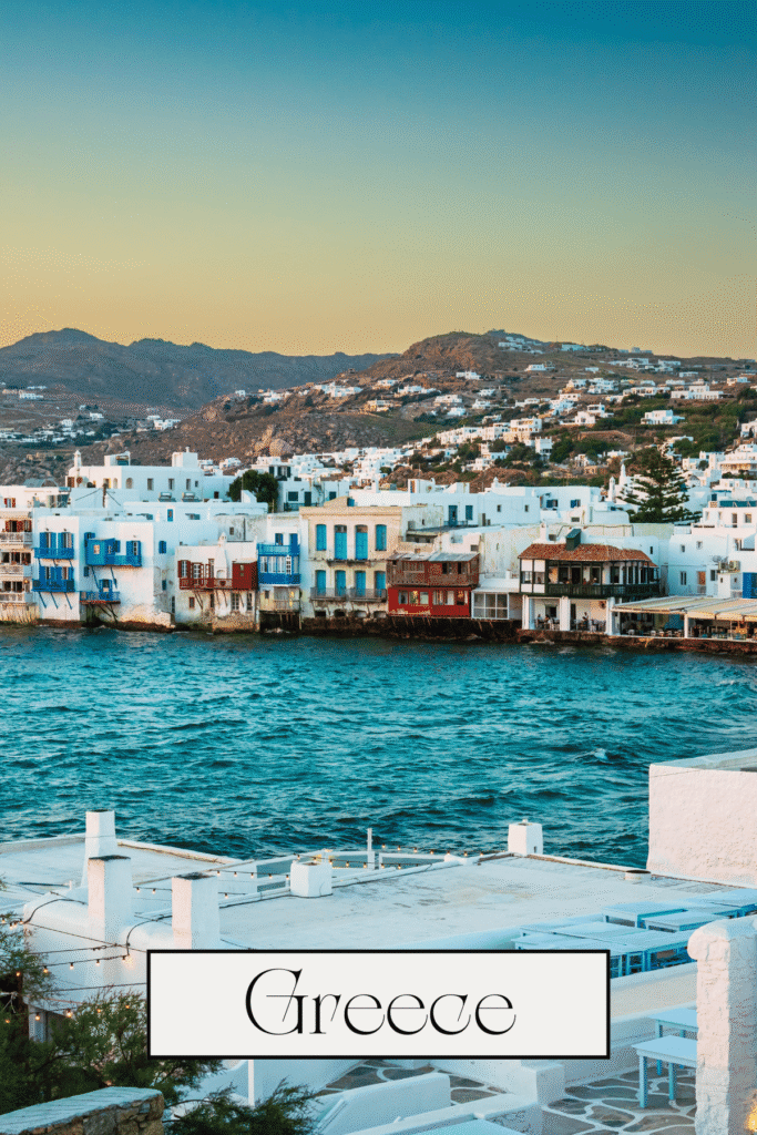 beautiful view of a greek town with white buildings in front of blue water